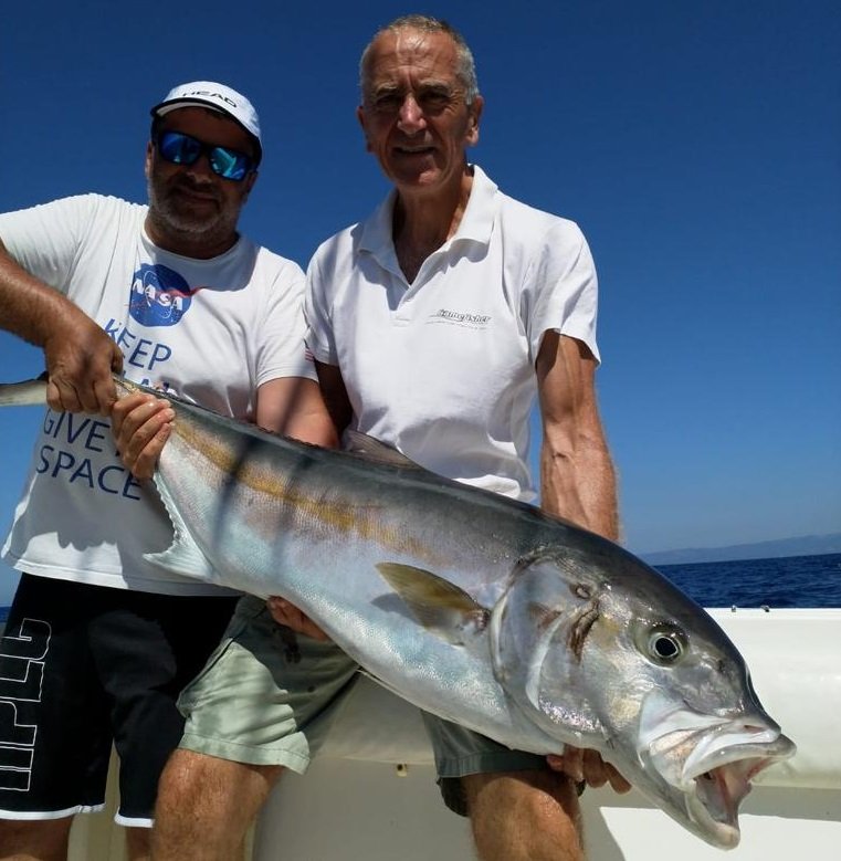 Massimo Deiana mostra una ricciola appena pescata durante un'uscita di pesca a Santa Teresa, Sardegna